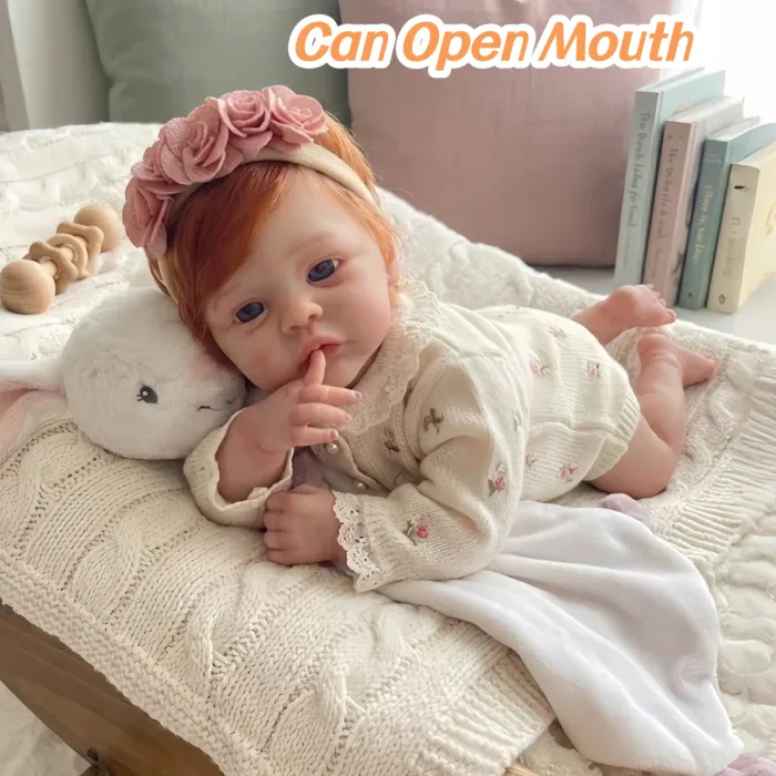 Adorable red-haired baby girl doll with open mouth and floral headband.