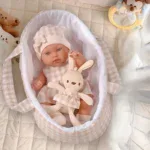 Adorable 14-inch basket reborn doll with blue eyes and soft clothing.