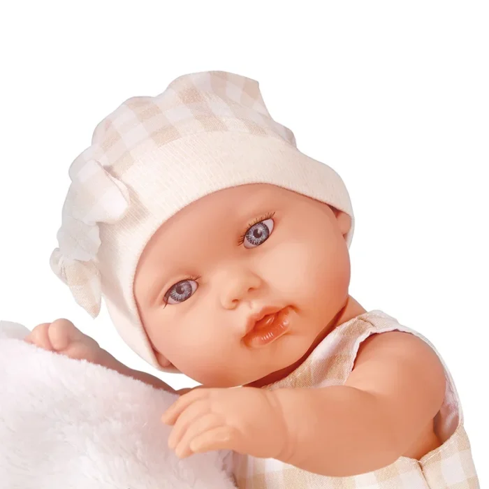 Realistic baby doll with blue eyes and soft clothing, wearing a white hat.