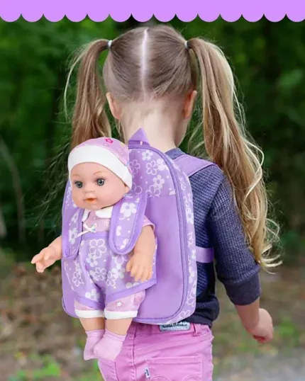 Child with purple floral doll carrier backpack outdoors.