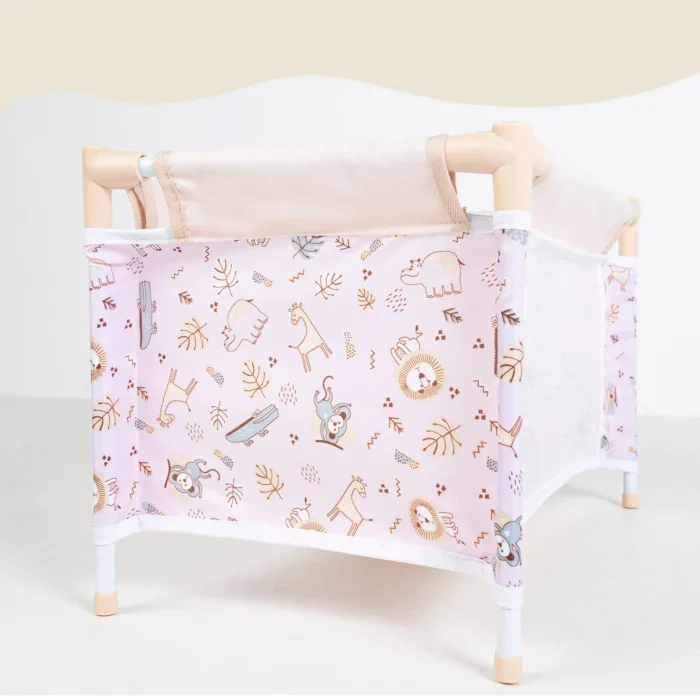 Pink doll travel cot with mesh sides and woodland animal print.