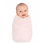 Adorable baby wrapped in a soft, plain cotton gauze blanket for comfort and warmth.