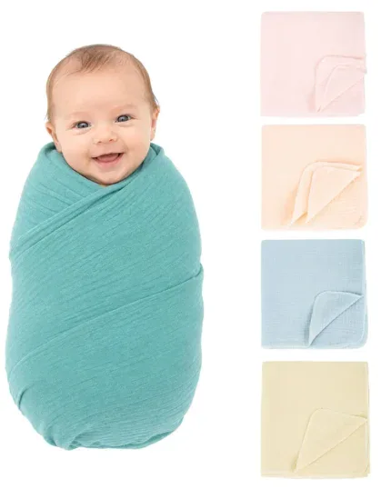 Baby wrapped in a soft turquoise cotton gauze blanket, smiling happily.