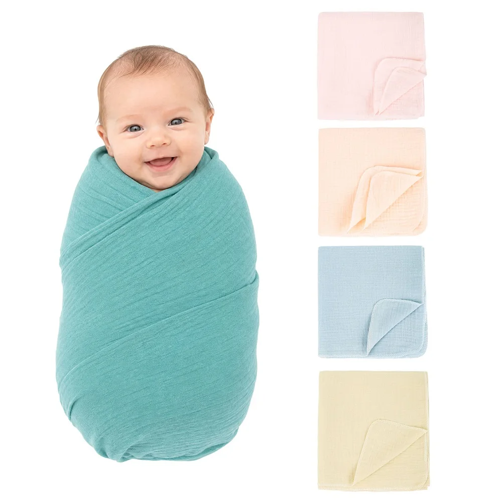 Baby Wrapped in Cotton Gauze Blanket Baby wrapped in a soft turquoise cotton gauze blanket, smiling happily.