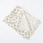 Soft muslin doll blanket with floral pattern for babies and photography.