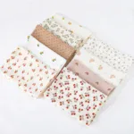 Set of muslin doll blankets with floral and fruit patterns in soft colors.