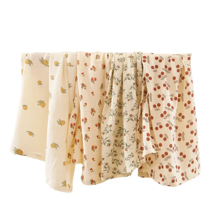 Set of four muslin doll blankets with floral and polka dot patterns.