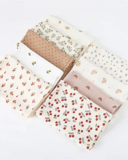 Set of muslin doll blankets with floral and fruit patterns in soft colors.