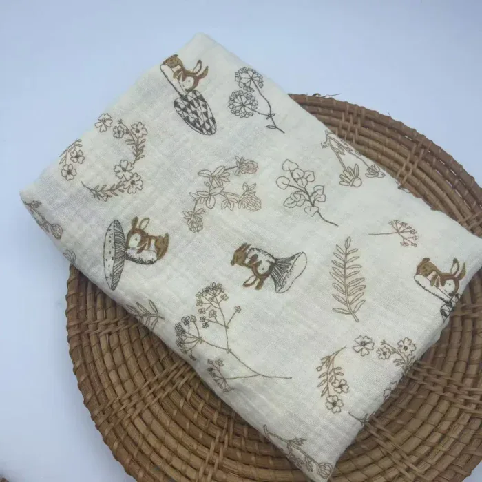 Soft muslin baby blanket with bunny and floral designs for newborns.
