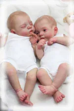 Zwei 45 cm große Reborn-Babypuppen schlafen nebeneinander.
