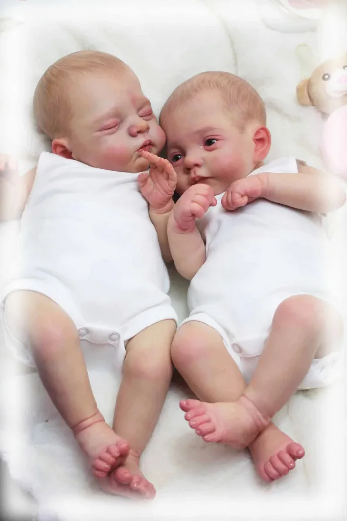 Zwei 45 cm große Reborn-Babypuppen schlafen nebeneinander.