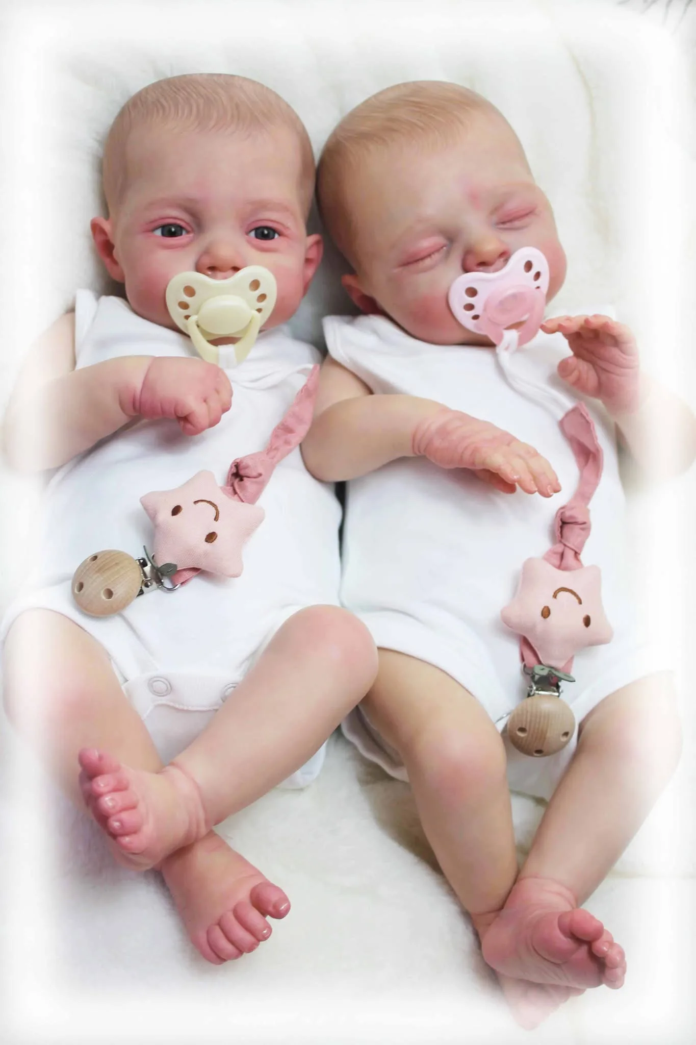 Noa & Maeve Zwillings-Reborn-Babypuppen Zwei realistische Zwillingsbabypuppen mit Schnullern und Plüschtieren.