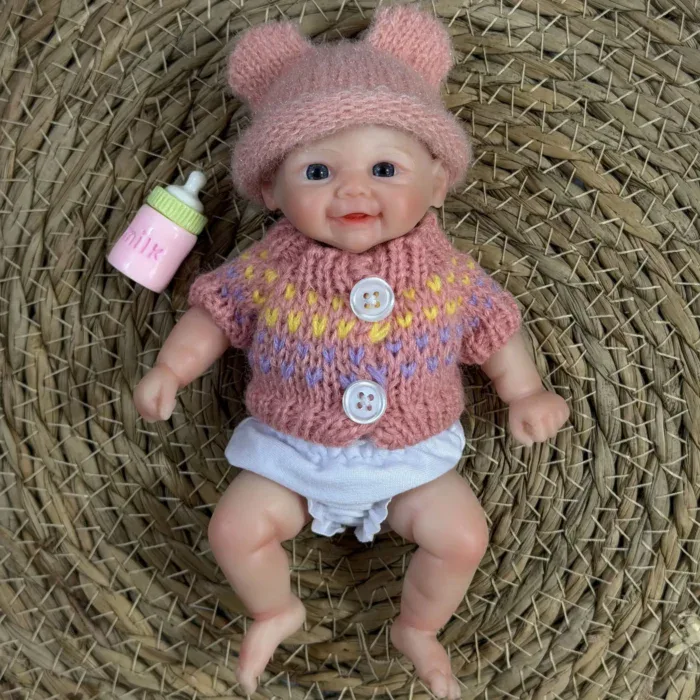 Entzückende Pip Chubby Baby Girl Silikon-Reborn-Puppe mit rosa Hütchen und Fläschchen.