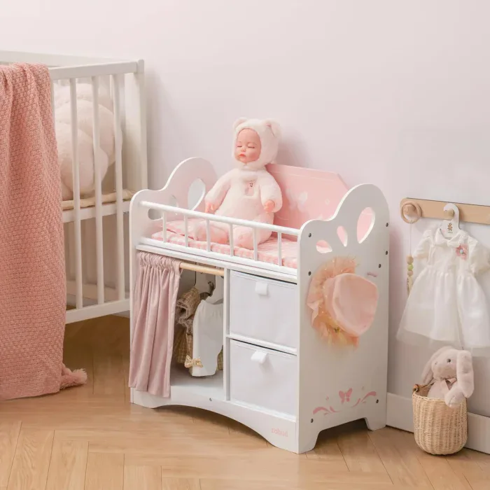 White wooden doll crib with pink bedding and plush doll, perfect for 20-inch dolls.