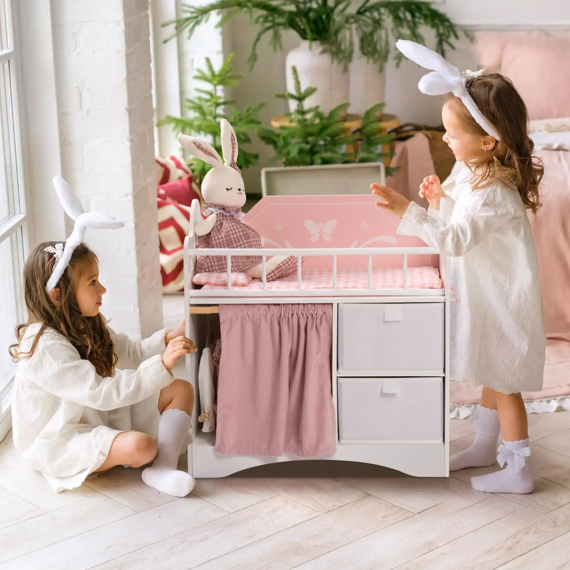 Wooden Doll Crib with Bunny Bedding Children playing with a wooden doll crib and bunny-themed bedding.