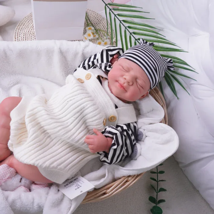 Realistische Silikon-Reborn-Babypuppe (Junge) mit gestreifter Mütze und kuscheliger Kleidung.
