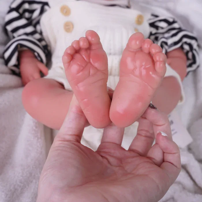 Nahaufnahme von Silikon-Babypuppenfüßen mit detailliert gestalteten Zehen und Hautstruktur.