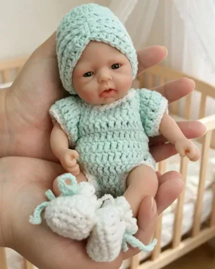 Entzückende Mini-Silikon-Reborn-Puppe mit Strickmütze und Strickoutfit.