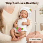 Reborn silicone baby doll in white knit outfit held gently.