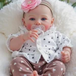 Blue-eyed reborn doll with pink flower headband and pacifier.